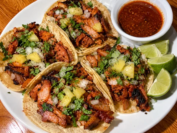 Al pastor tacos with lime and salsa